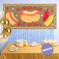 banner styled behind hot dog bar at party