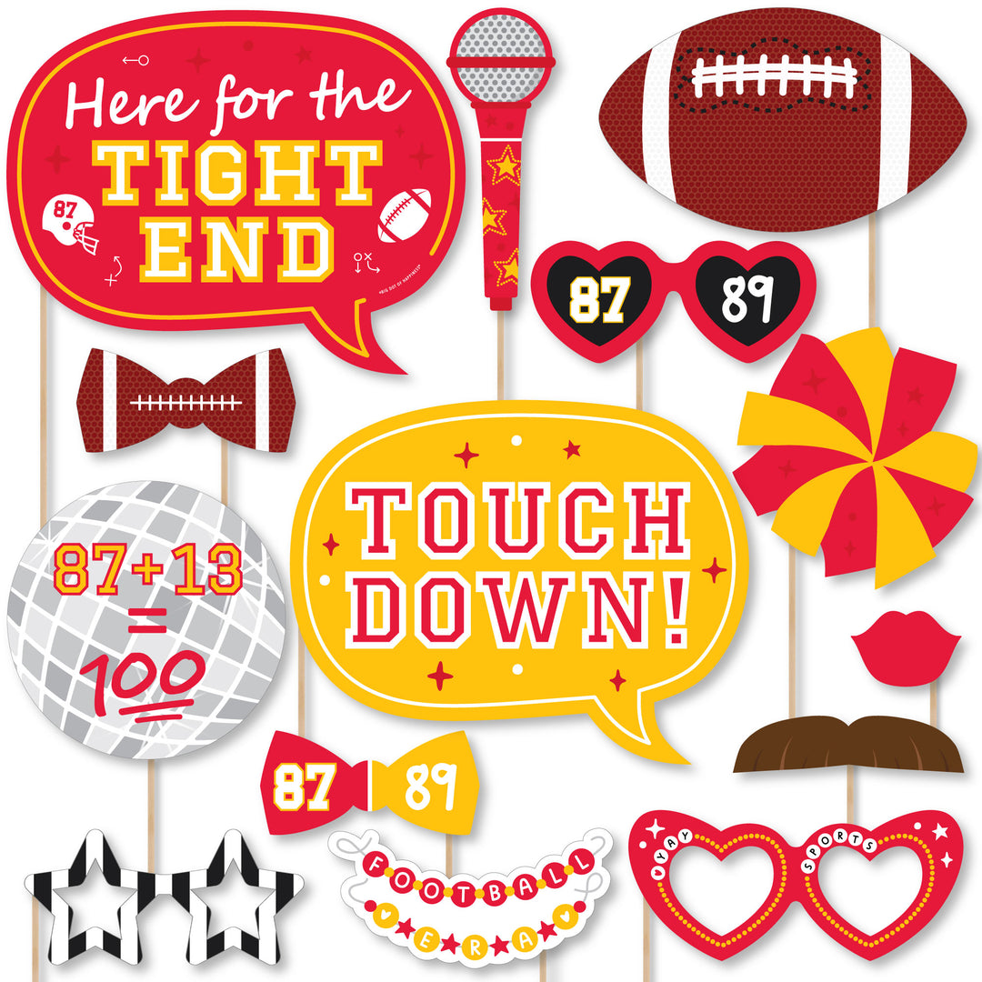 A collection of red and gold colored photo booth props with sports-themed elements, including glasses, bow ties, lips, mustaches, a football, a helmet, a foam finger, a disco ball, a friendship bracelet, a microphone, and talk bubbles with football-related phrases.