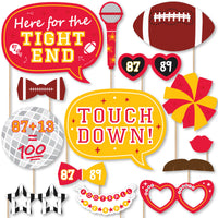 A collection of red and gold colored photo booth props with sports-themed elements, including glasses, bow ties, lips, mustaches, a football, a helmet, a foam finger, a disco ball, a friendship bracelet, a microphone, and talk bubbles with football-related phrases.