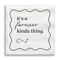 White napkin with black text 'it's a forever kinda thing. C + J' on a white background