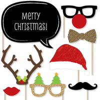 A collection of Christmas-themed photo booth props including glasses, hats, mustaches, bow ties, lips, and signs with festive messages, all on sticks for easy use.