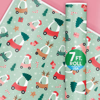Christmas-themed wrapping paper with small vehicles and trees on a light green background, featuring a roll of paper.