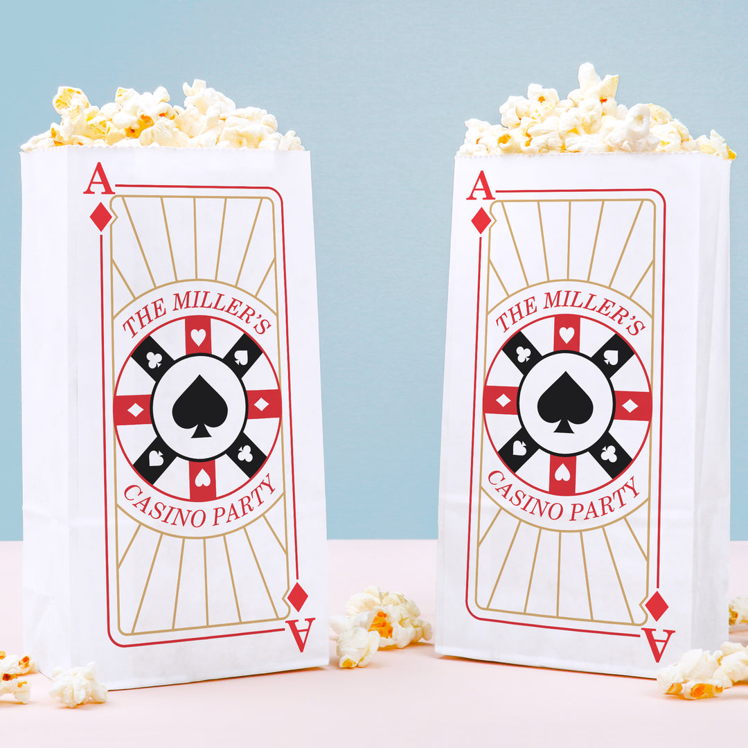 Two popcorn bags with playing card design and 'The Miller's Casino Party' text on a light blue background.