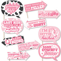 A collection of pink and black photo booth props with humorous text related to a bachelorette party, including phrases like 'Last Rodeo' and 'Giddy Up'.