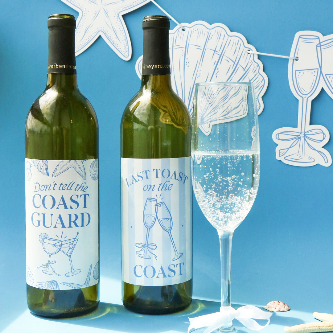 Two wine bottles with humorous labels next to a glass of champagne on a blue background with decorative elements.