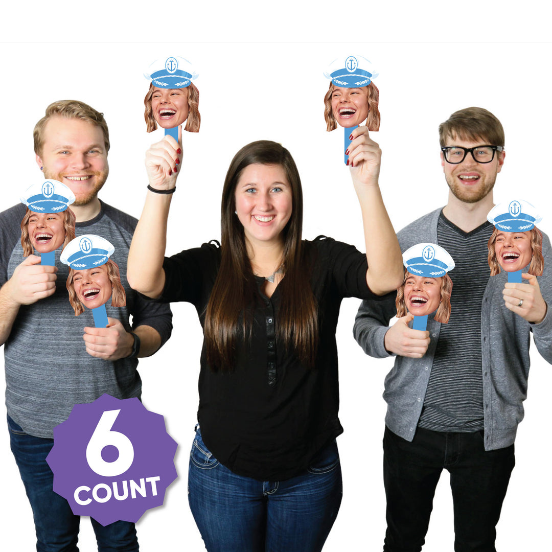Guests using nautical captain hat face paddles at bachelorette party photo booth