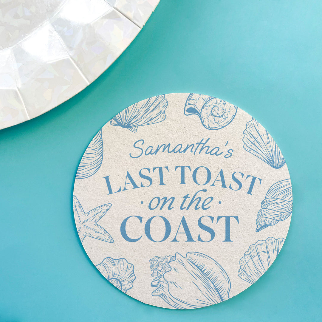 Round coaster with shell design and text 'Samantha's Last Toast on the Coast' on a teal background