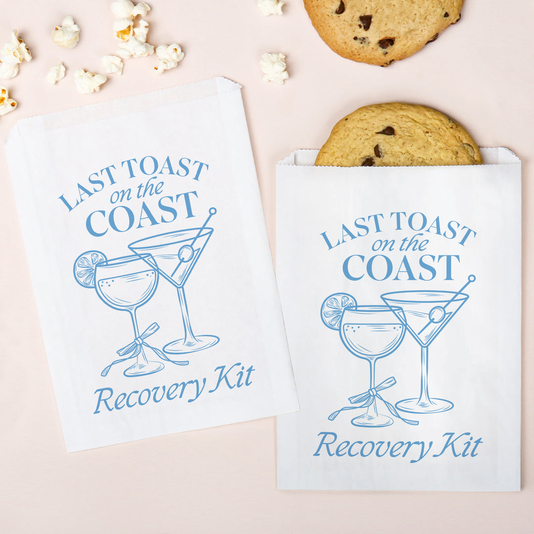 Two 'Last Toast on the Coast Recovery Kit' bags with cocktail graphics and cookies on a light background.