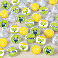 An array of round candy stickers with 'PICKLEBALL' text and graphics, including a pickleball court and ball, displayed on a wooden surface.