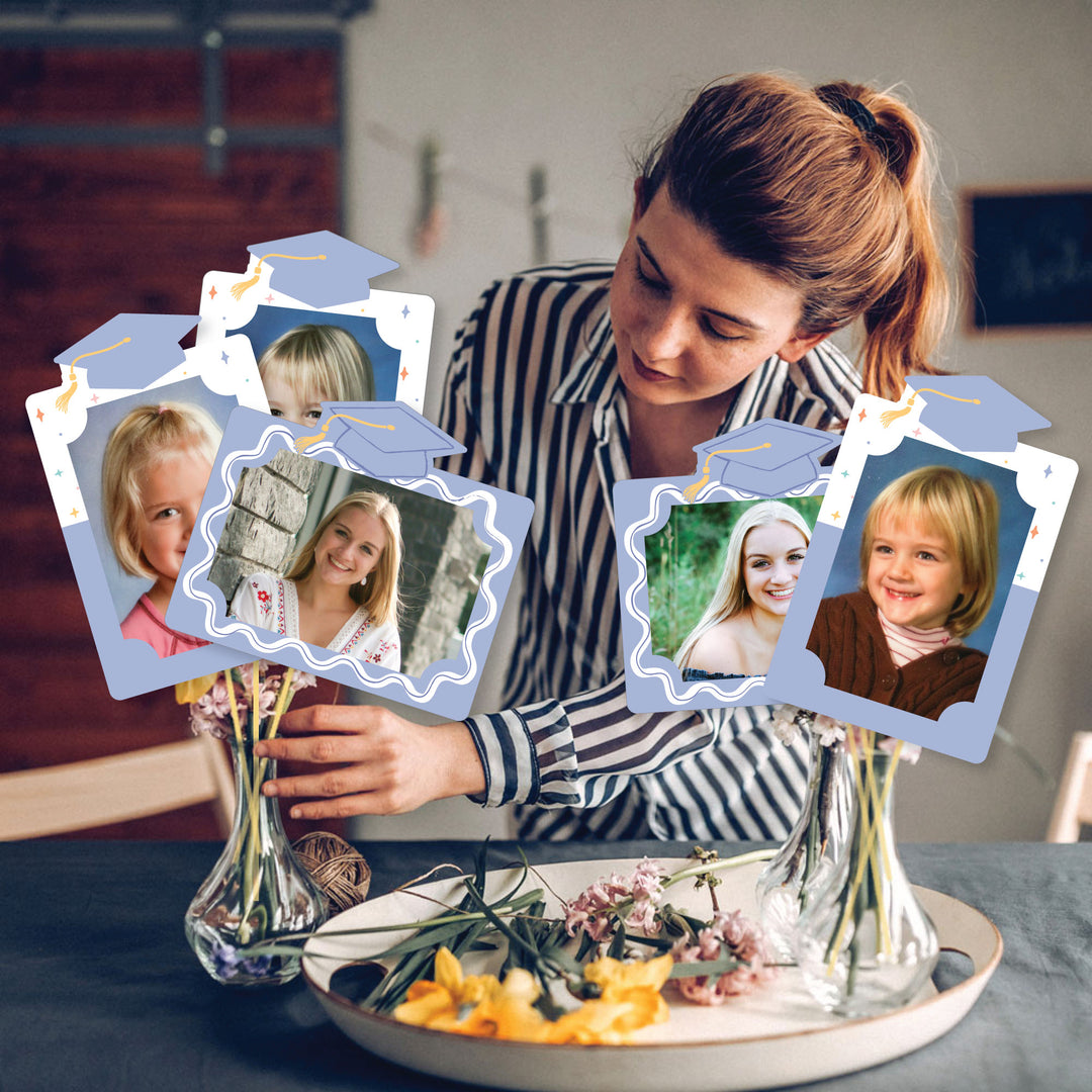 Woman arranging photo frames with images on a table.