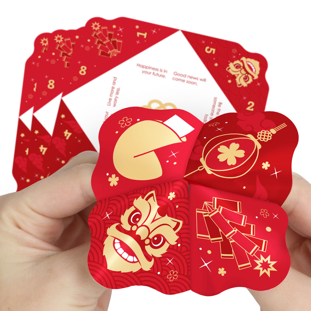 A person holding a red and gold colored fortune teller with Lunar New Year themed illustrations, including Chinese lanterns and a dragon.