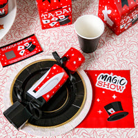Magic show themed arty supplies on a red table with plates and cups