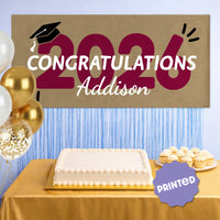 Maroon 2026 graduation banner used as party backdrop