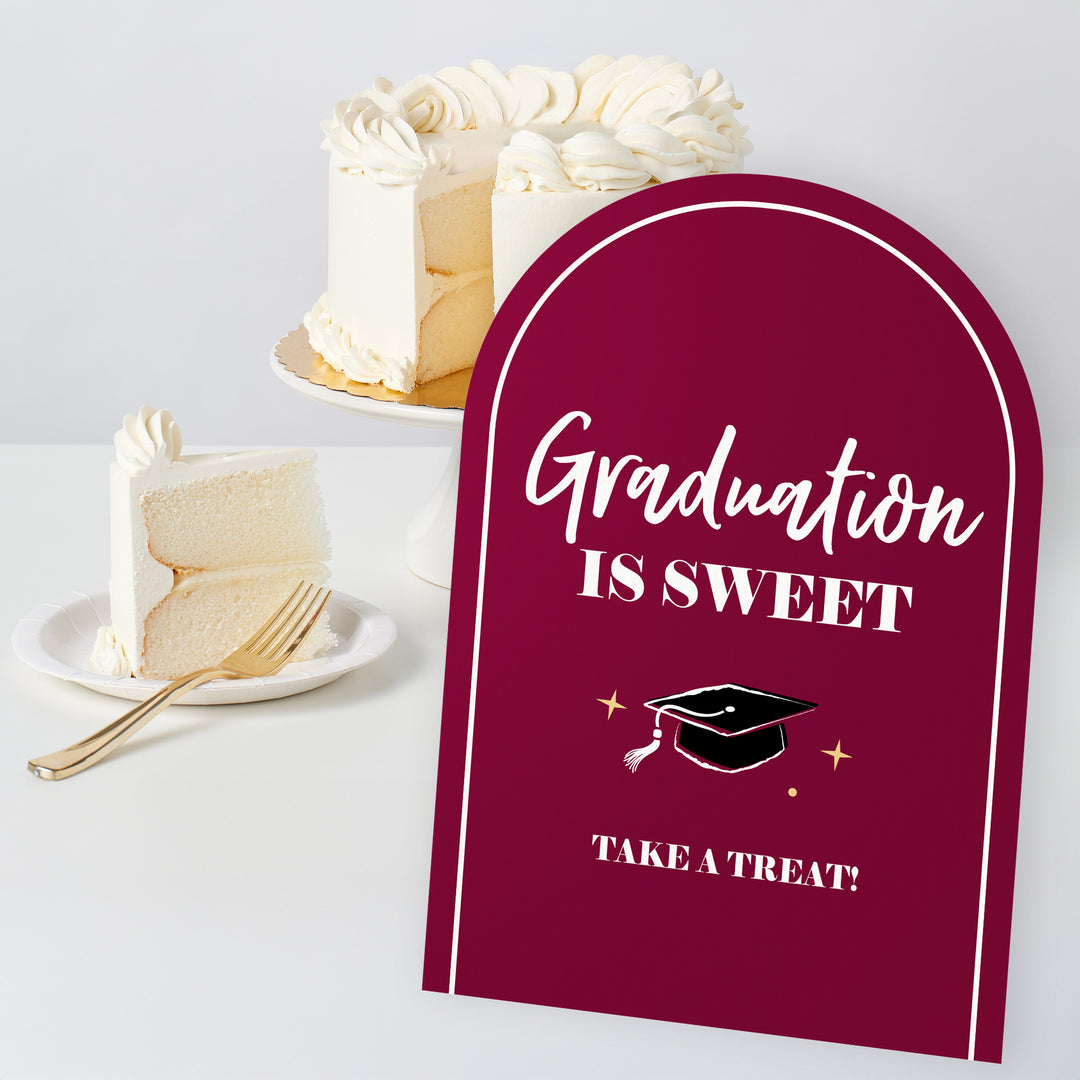 Maroon grad party sign design close-up for desserts and drinks table