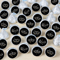 An array of round candy stickers with a black background and a silver Venetian mask design, displayed in rows on a light surface.
