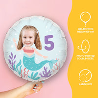 Turn your photo into a mermaid on a Round inflatable balloon with mermaid design and number 5, held by a hand on a pink background.
