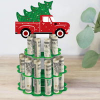 A decorative DIY red truck Christmas party money holder gift, with slots to hold rolled-up bills, designed to look like a tree with a base, middle, and top layer.
