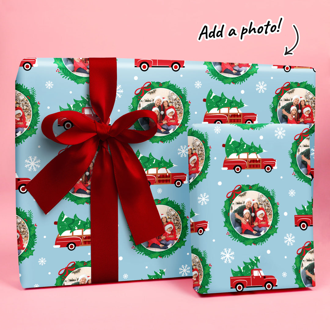 Christmas-themed gift wrap with red ribbon on a pink background