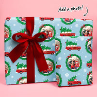 Christmas-themed gift wrap with red ribbon on a pink background