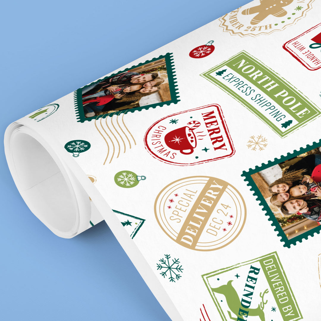 Roll of Christmas-themed wrapping paper with stamps and photos on a blue background