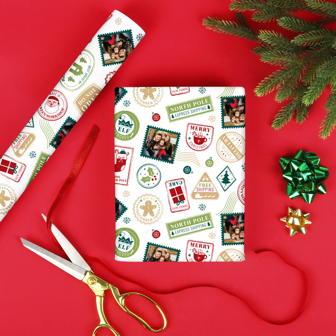 Christmas-themed wrapping paper with stamps, a bow, and scissors on a red background