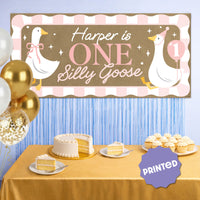 Pink first birthday party backdrop with goose banner