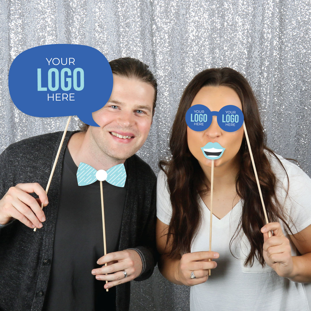 People taking selfies with custom logo photo booth props at corporate party