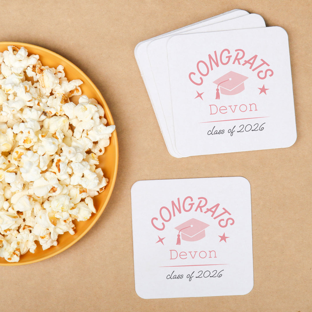 Pink personalized graduation coasters on drink table
