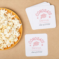 Pink personalized graduation coasters on drink table