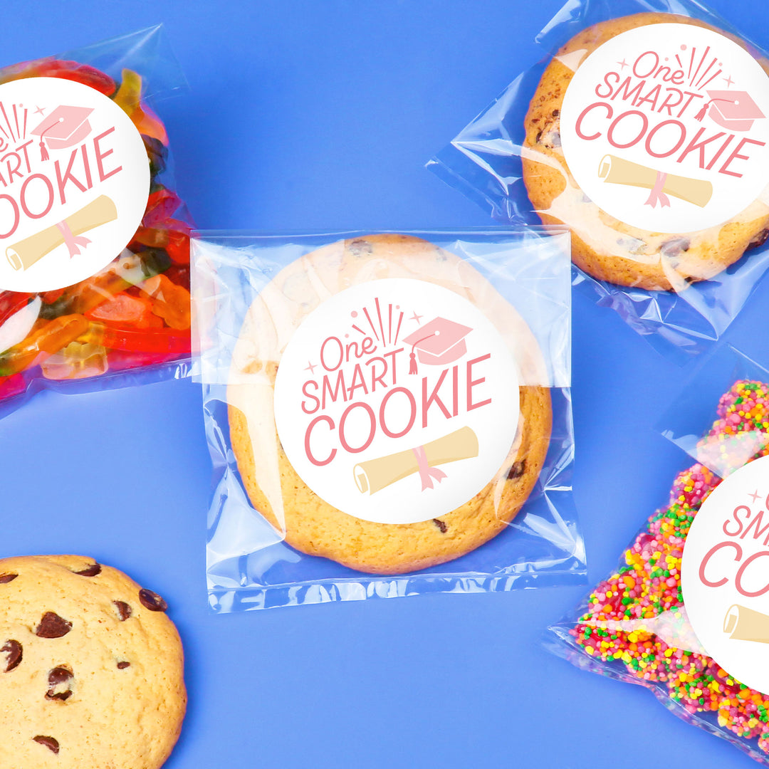 Pink graduation cookie favors on dessert table