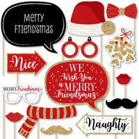 A collection of red and gold Christmas-themed photo booth props, including signs, hats, glasses, and mustaches.