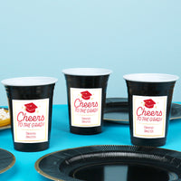 Red personalized graduation cups on dessert table