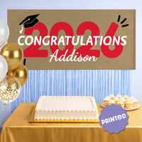 Red 2026 graduation banner hanging as party backdrop