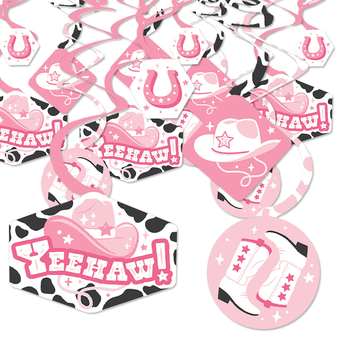 A collection of pink and black party decoration swirls with western-themed designs such as cowgirl hats and horseshoes, laid out flat on a white background.