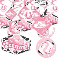 A collection of pink and black party decoration swirls with western-themed designs such as cowgirl hats and horseshoes, laid out flat on a white background.