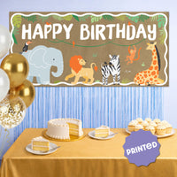 Jungle safari birthday banner displayed behind dessert table