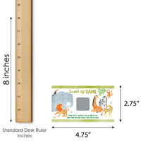 Small scratch-off game card with animals on a white background, next to a standard desk ruler for scale.