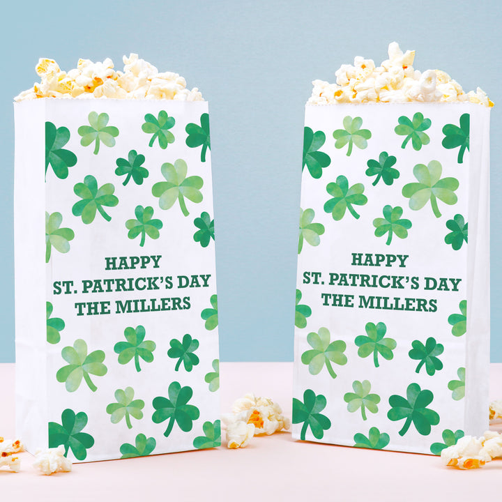 Two popcorn boxes with shamrock pattern and 'Happy St. Patrick's Day' text on a light blue background.