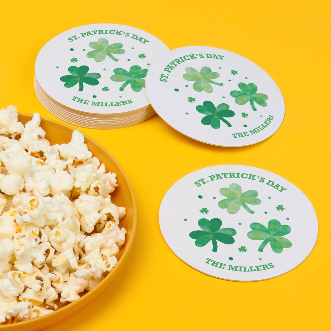 St. Patrick's Day coasters with shamrock design and a bowl of popcorn on a yellow background