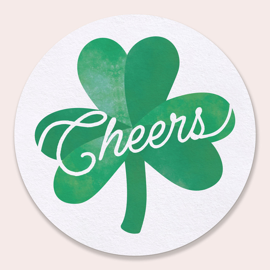Round coaster with green shamrock design and 'Cheers' text on a beige background