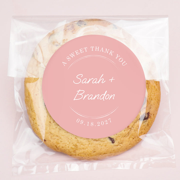 Cookie bag with a personalized label on a pink background for wedding favors