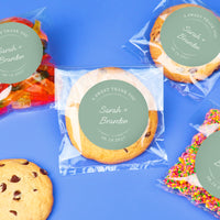 Cookies with personalized sage green labels on a blue background