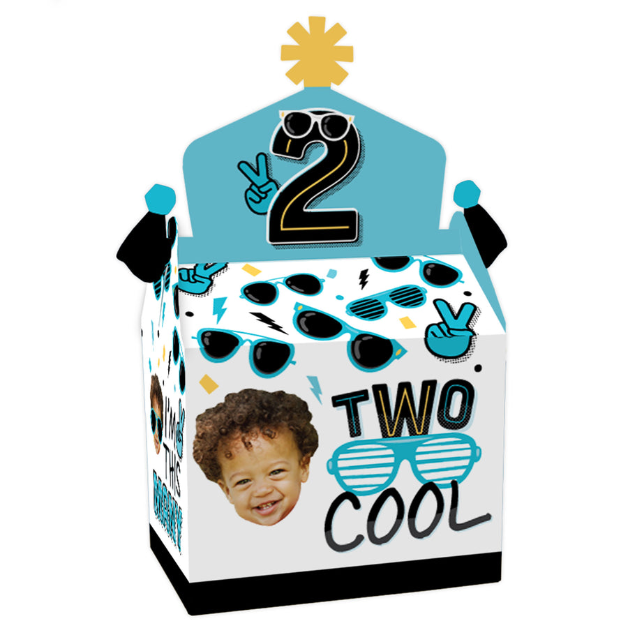 A blue gable treat box with a '2' symbol, sunglasses illustrations, and a custom photo space, designed for a boy's 2nd birthday party.
