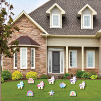Decorative unicorn and rainbow yard stakes in front of a house