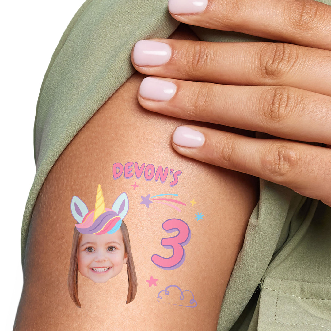 Custom unicorn Temporary tattoo with a child's face and 'Devon's 3' on a person's arm, with a hand touching the tattoo.
