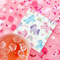 Unicorn-themed paper napkins on a pink background with confetti