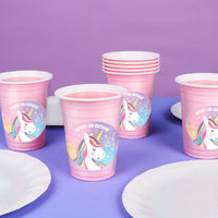 Pink party cups with unicorn designs on a purple background