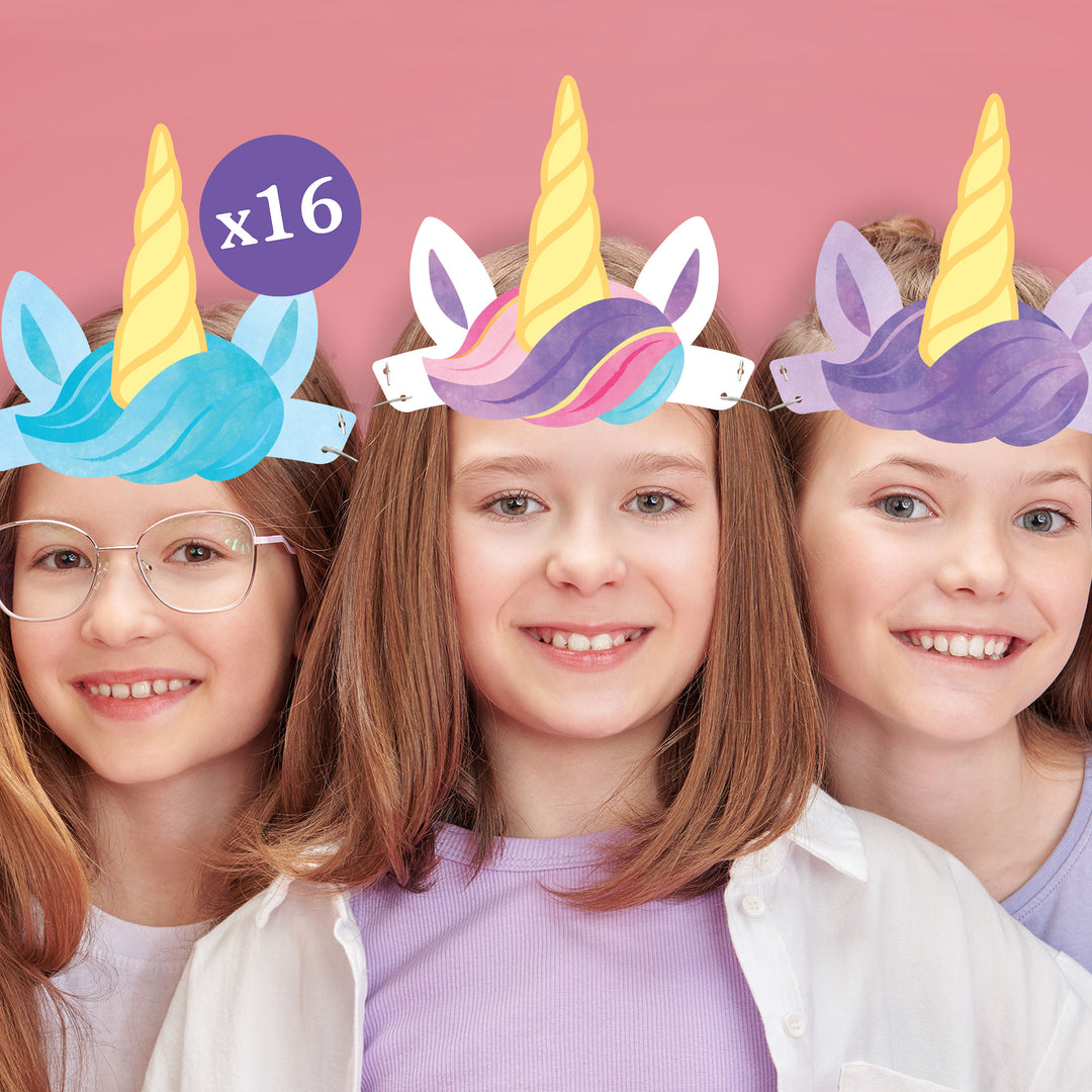 Three children wearing colorful unicorn headbands against a pink background