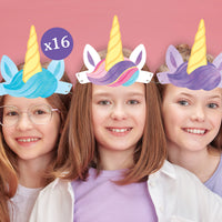 Three children wearing colorful unicorn headbands against a pink background