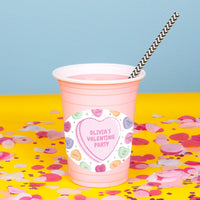 Pink cup with straw and Valentine's Day-themed label for classrooms